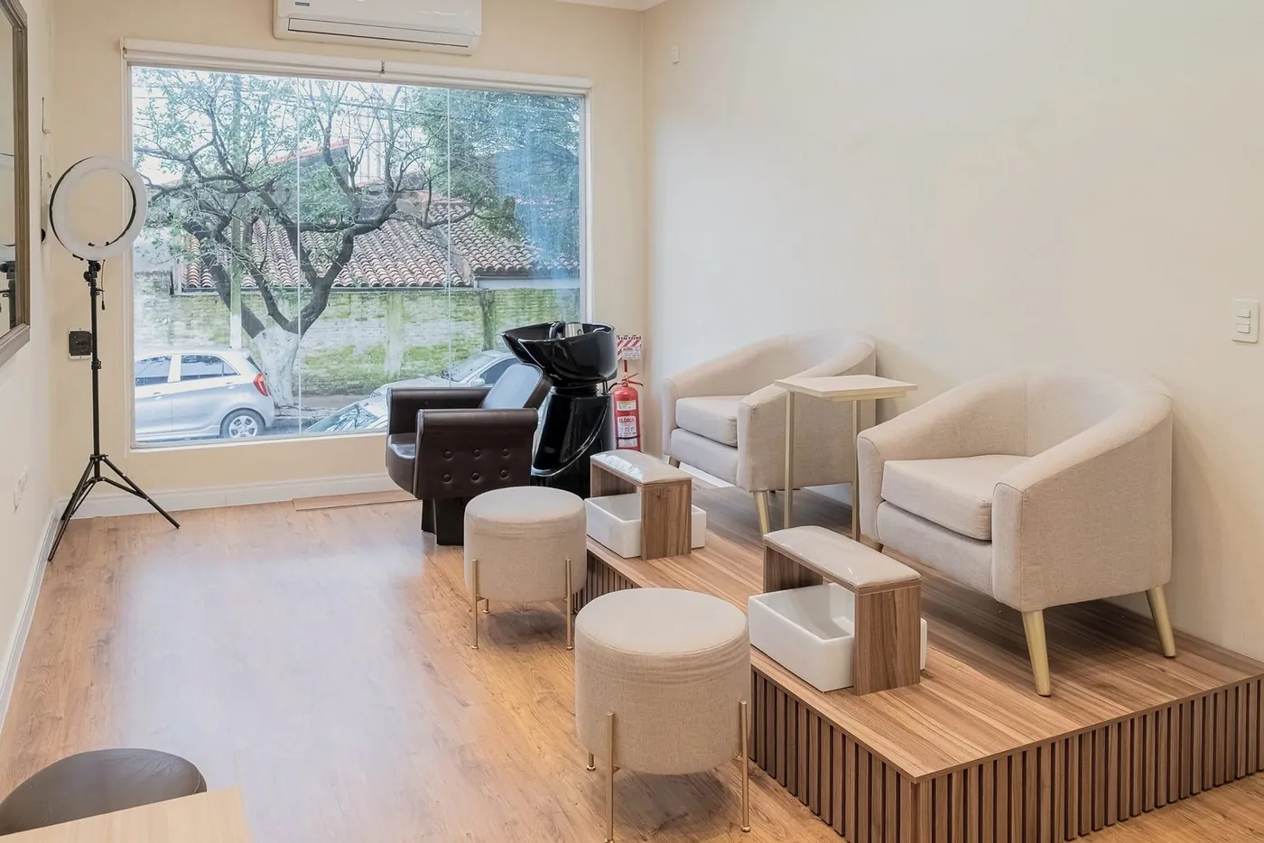Spa de manos y pies con sillones tapizados, piletas sobre tarima de madera y ventanal
